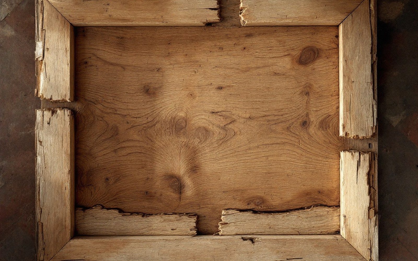 The reverse of an old wooden panel painting showing its grain, joins and a cradle, even light